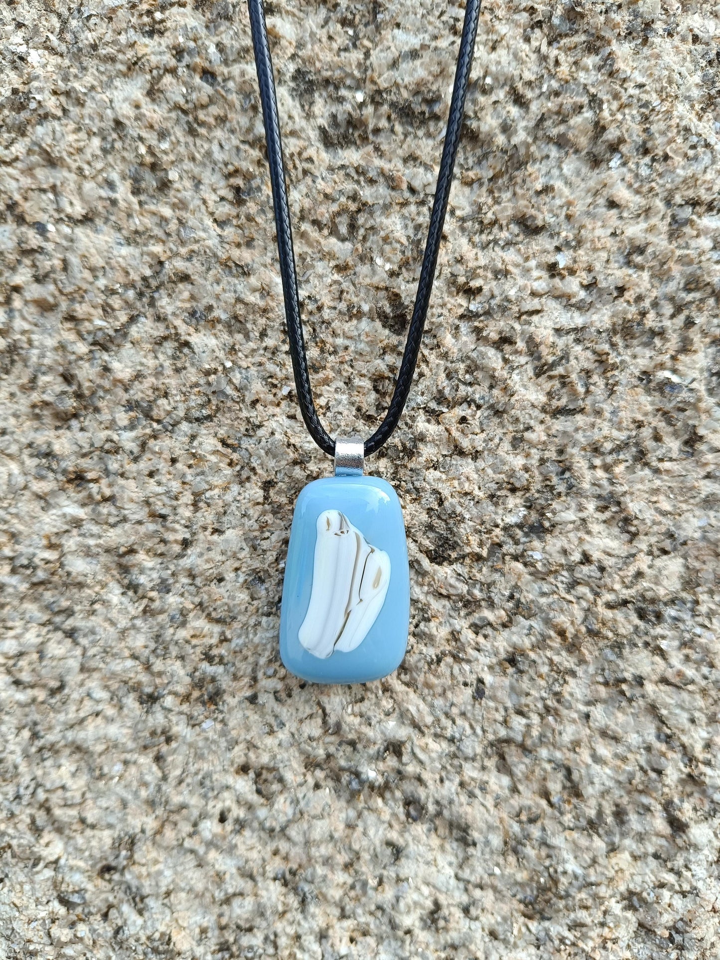 blue and white pendant hangin against a granite wall