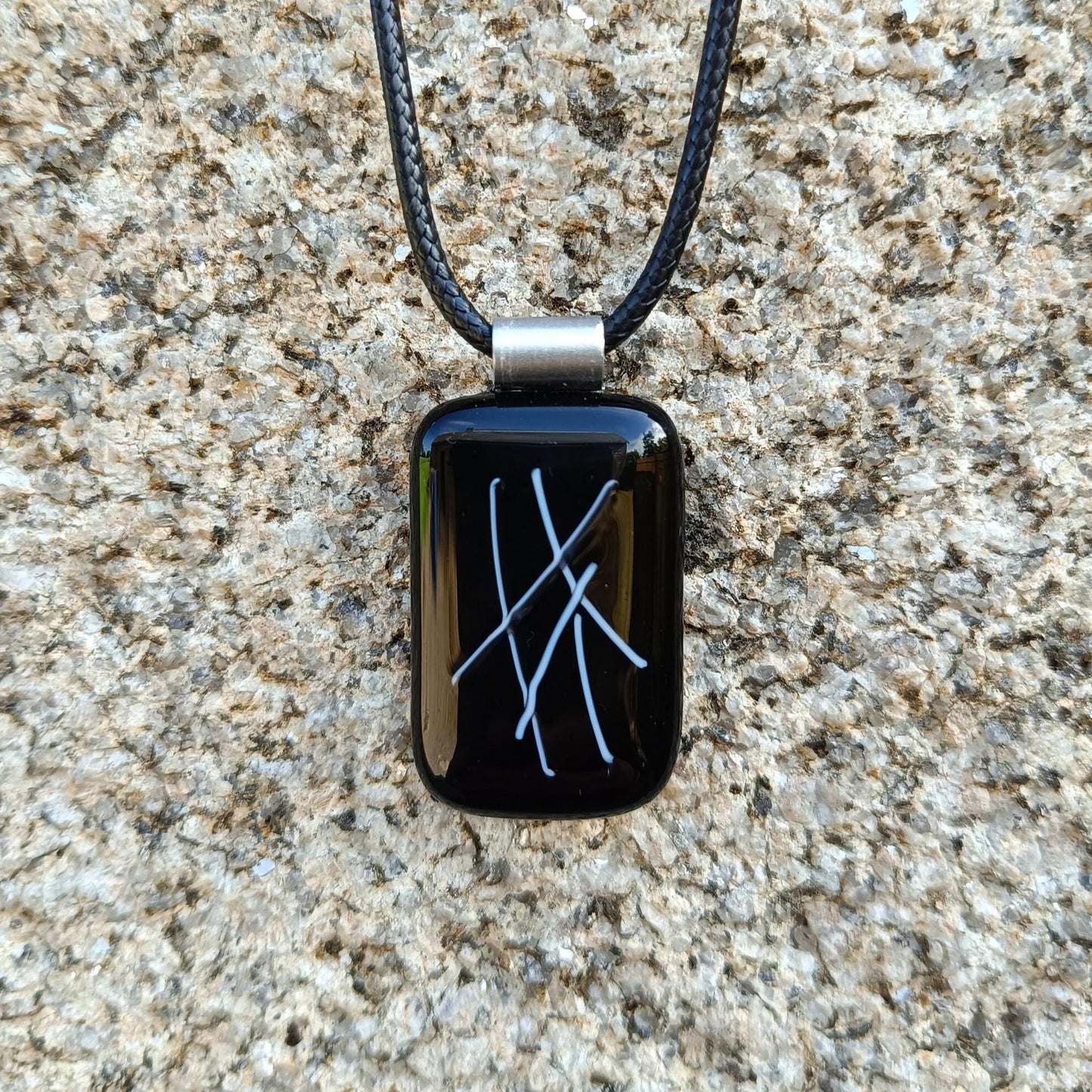 hand crafted black glass pendant hanging on a cord