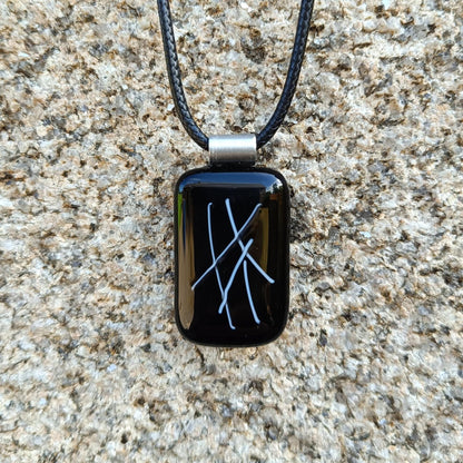 hand crafted black glass pendant hanging on a cord