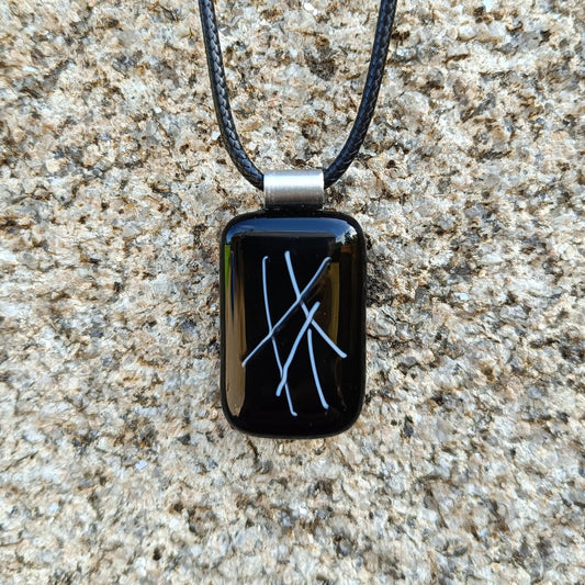 hand crafted black glass pendant hanging on a cord