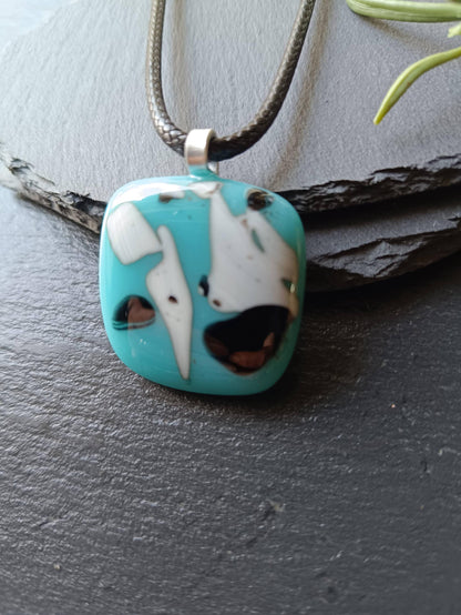 Fused glass pendant on black cord; turquoise blue square with white and black abstract patterns, handmade, easy to mail.