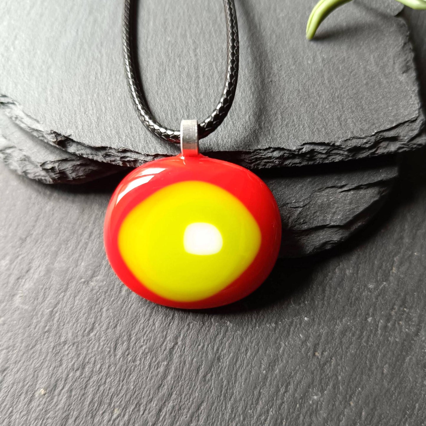 Round fused glass pendant in red, yellow and lime green on a black chain; handmade jewelry, statement pendant.