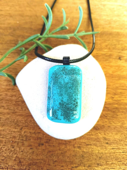 blue grungy style pendant on a black cord