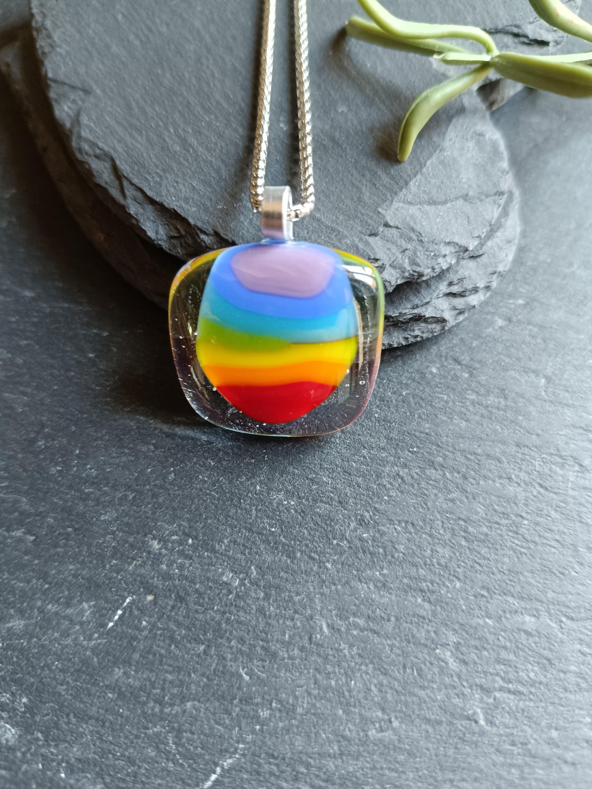 Handmade fused glass rainbow pendant necklace on a silver chain; colorful stripes in a clear rounded-square pendant.