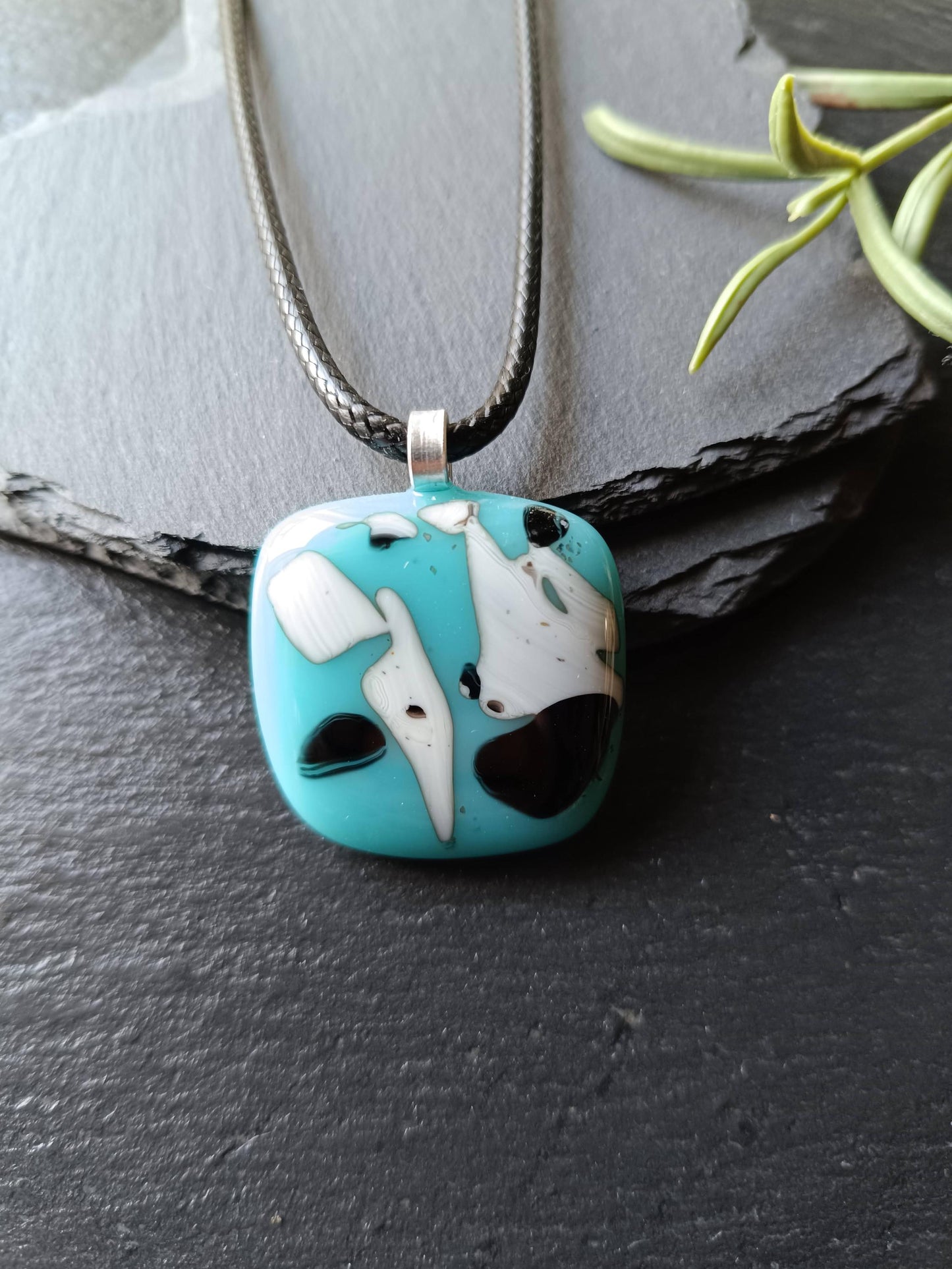 Fused glass pendant on black cord; turquoise blue square with white and black abstract patterns, handmade, easy to mail.
