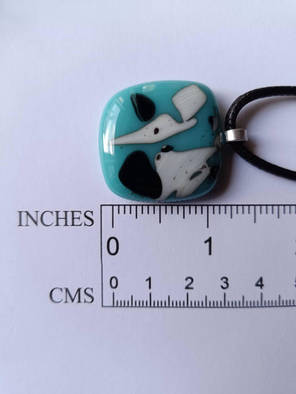 Fused glass pendant on black cord; turquoise blue square with white and black abstract patterns, handmade, easy to mail.