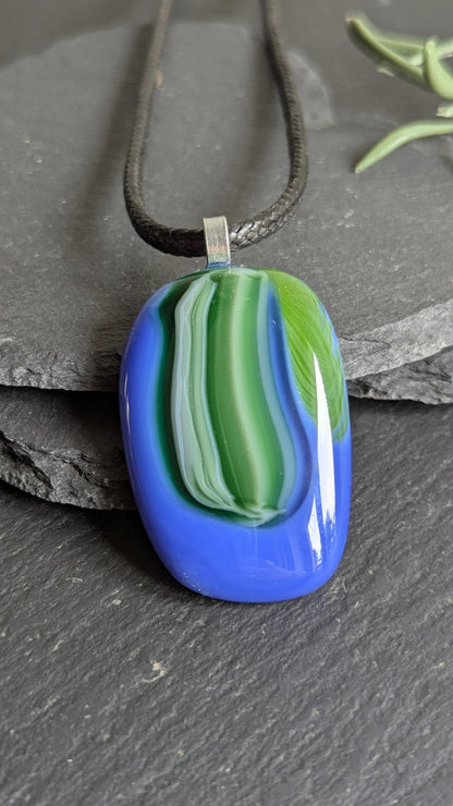 Fused glass pendant on black cord necklace; oval blue pendant with green swirls, handmade jewellery, unique one-of-a-kind.