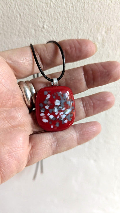 Red fused glass speckled pendant on brown cord necklace; one-of-a-kind handmade jewellery.
