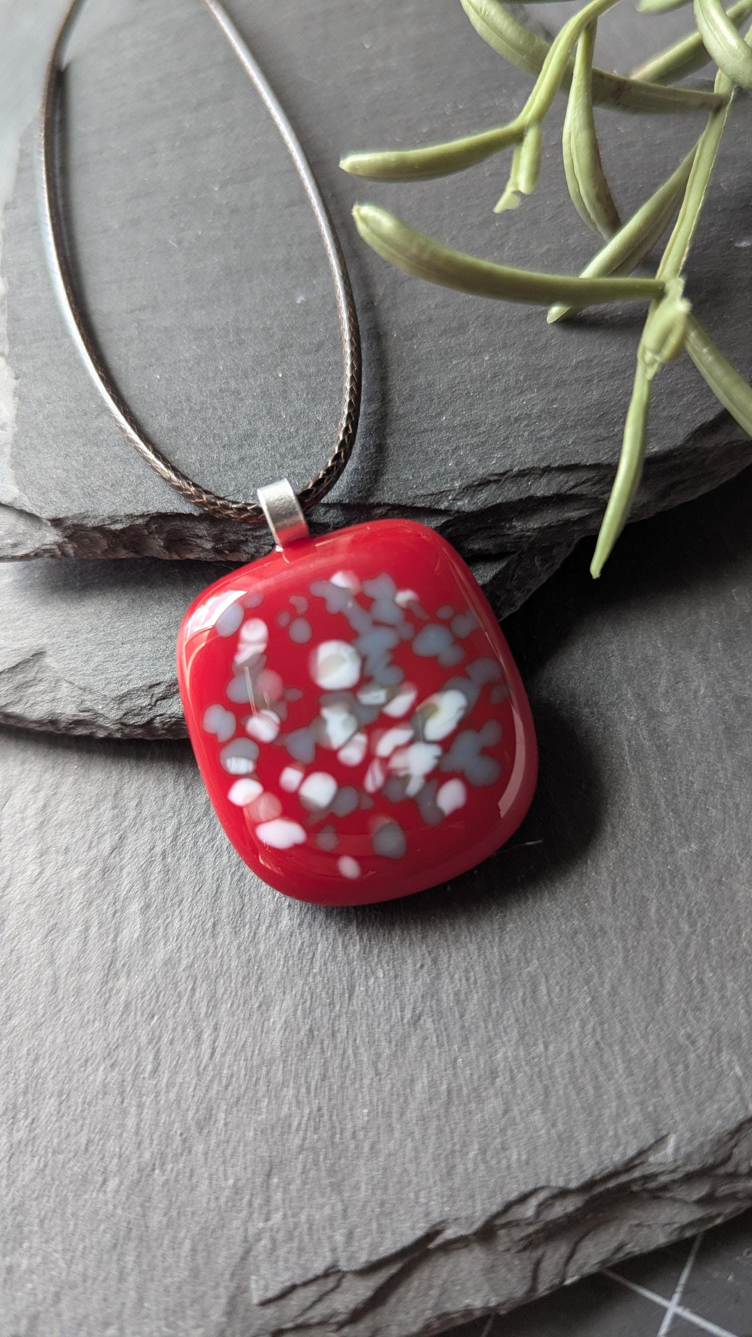 Red fused glass speckled pendant on brown cord necklace; one-of-a-kind handmade jewellery.