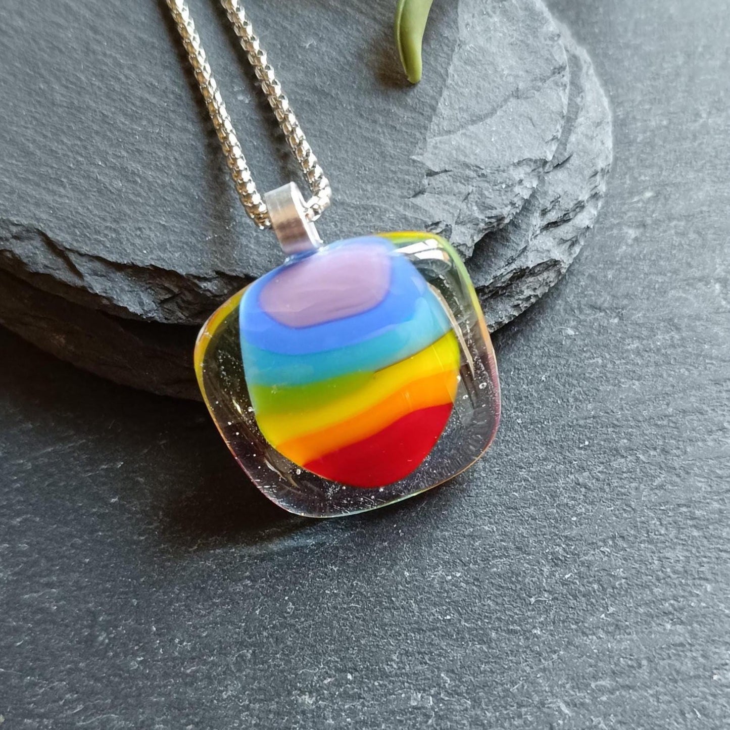 Handmade fused glass rainbow pendant necklace on a silver chain; colorful stripes in a clear rounded-square pendant.