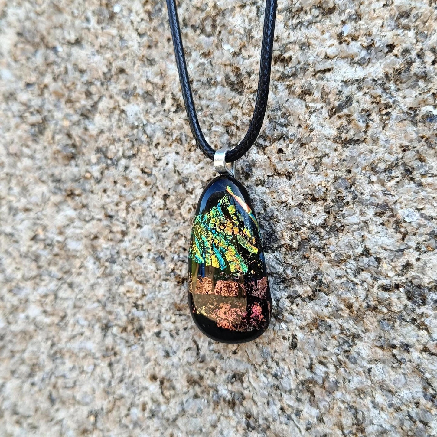 Fused glass pendant necklace with dichroic, iridescent greens, golds and pinks on black glass; corded, handmade jewellery.