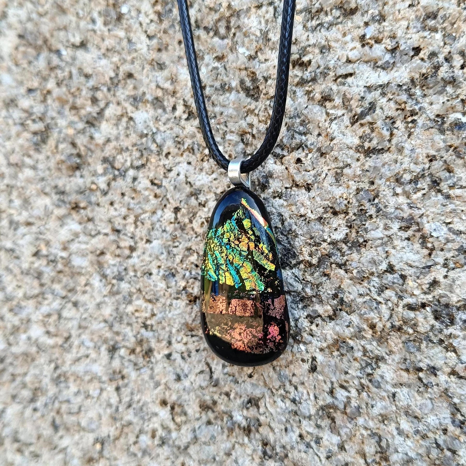 Fused glass pendant necklace with dichroic, iridescent greens, golds and pinks on black glass; corded, handmade jewellery.