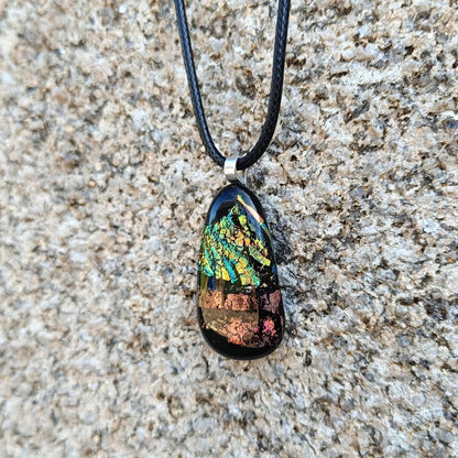 Fused glass pendant necklace with dichroic, iridescent greens, golds and pinks on black glass; corded, handmade jewellery.