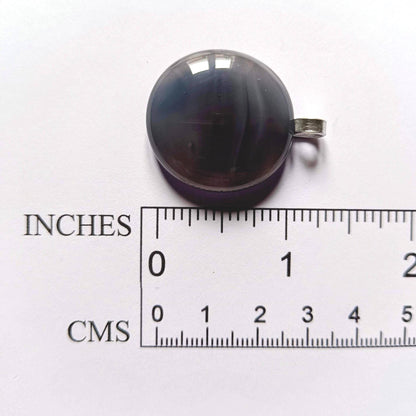 grey pendant next to a ruler