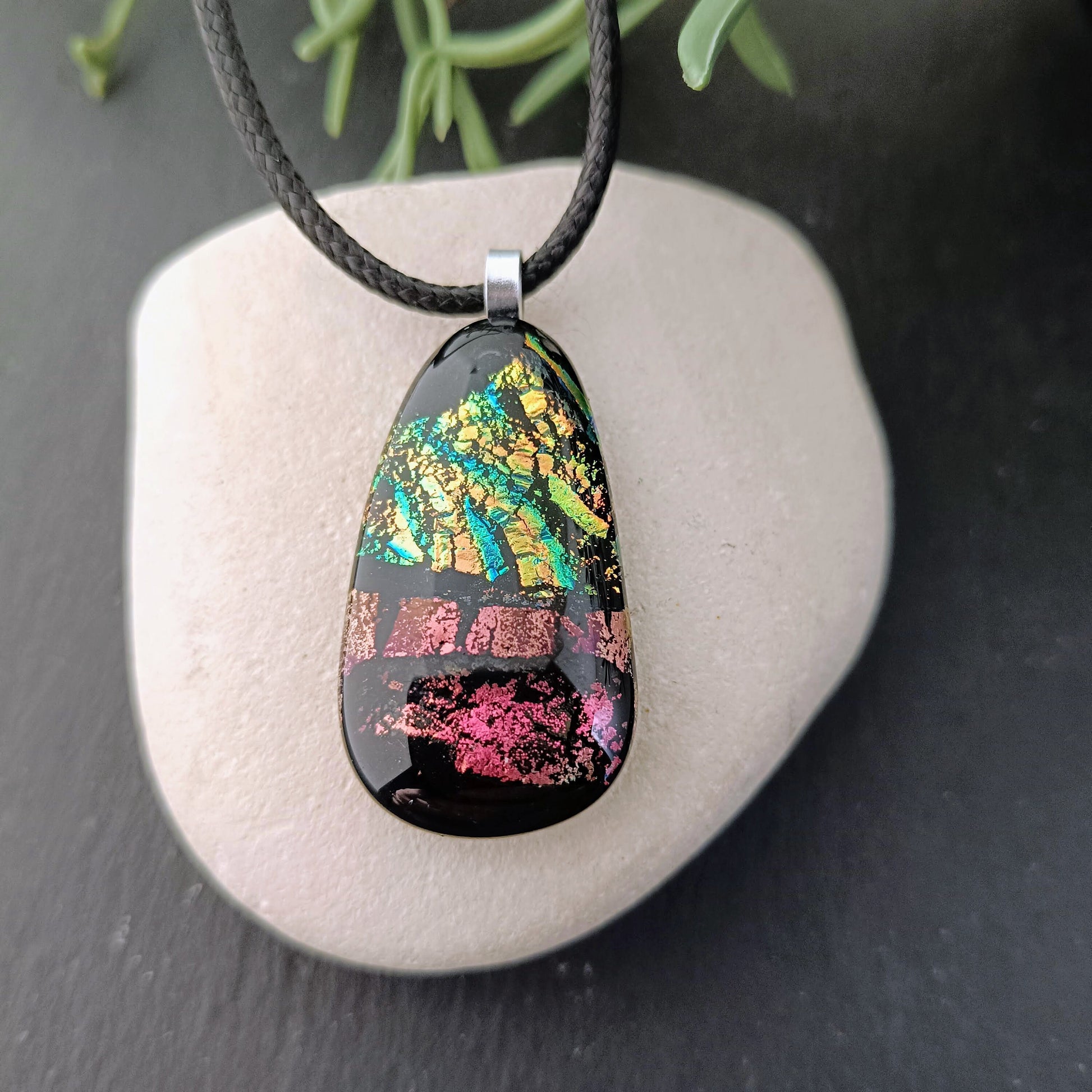 Fused glass pendant necklace with dichroic, iridescent greens, golds and pinks on black glass; corded, handmade jewellery.