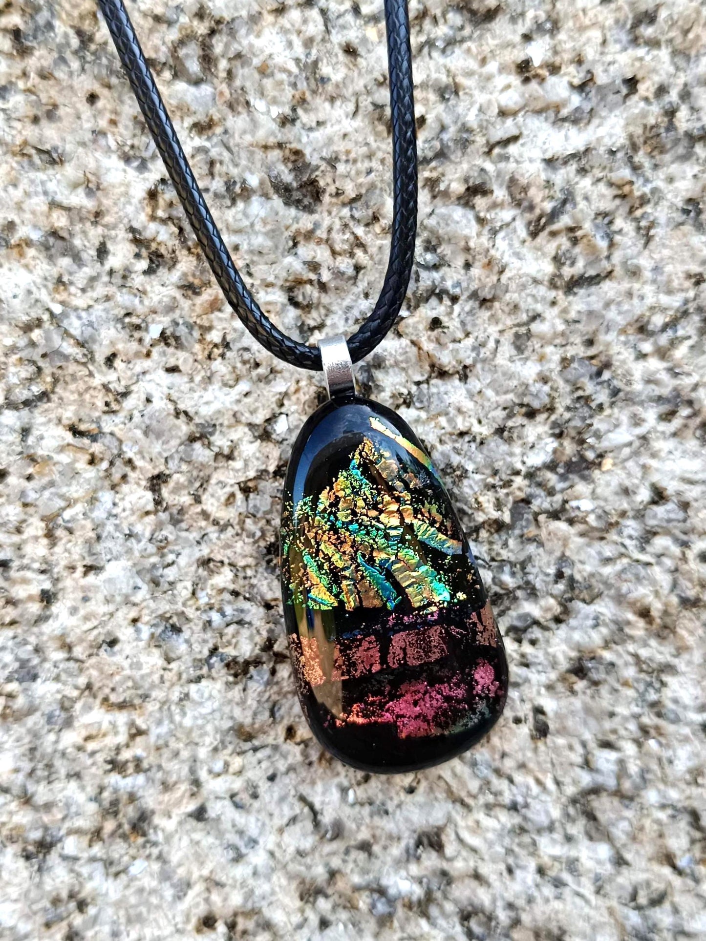 Fused glass pendant necklace with dichroic, iridescent greens, golds and pinks on black glass; corded, handmade jewellery.