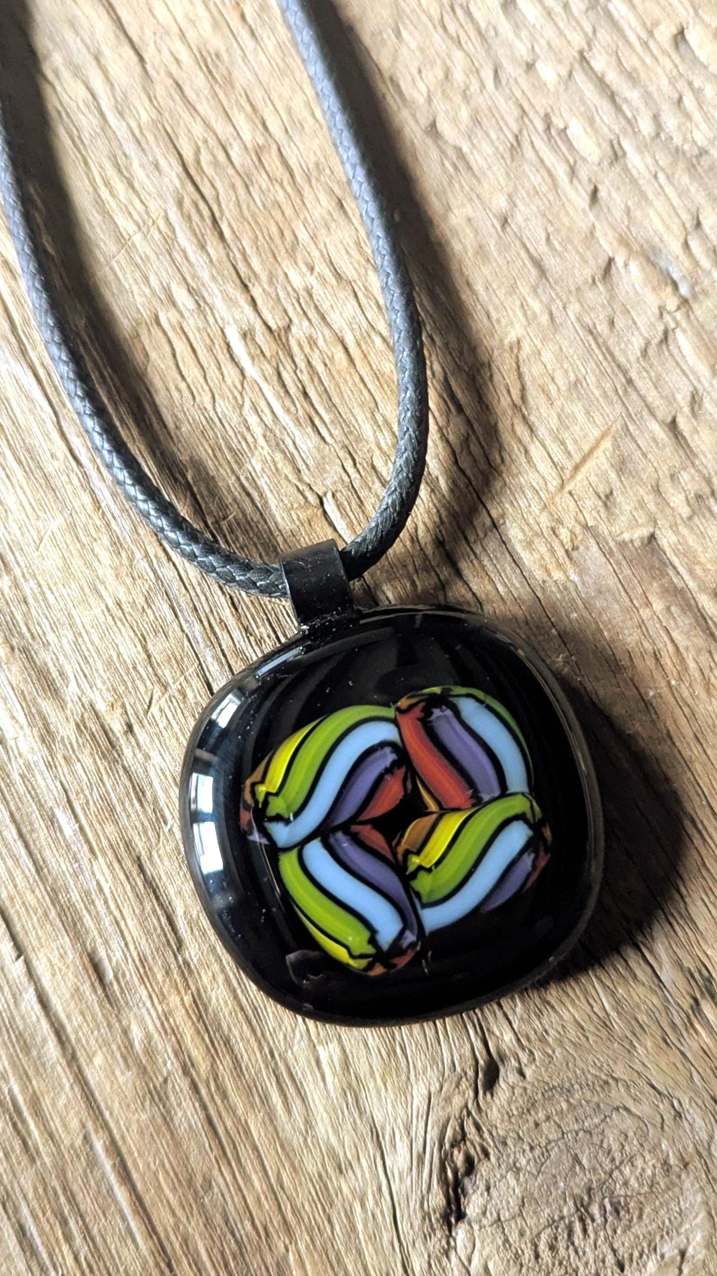 Fused glass pendant on black cord necklace; vibrant rainbow swirls, handmade one-of-a-kind letterbox gift.
