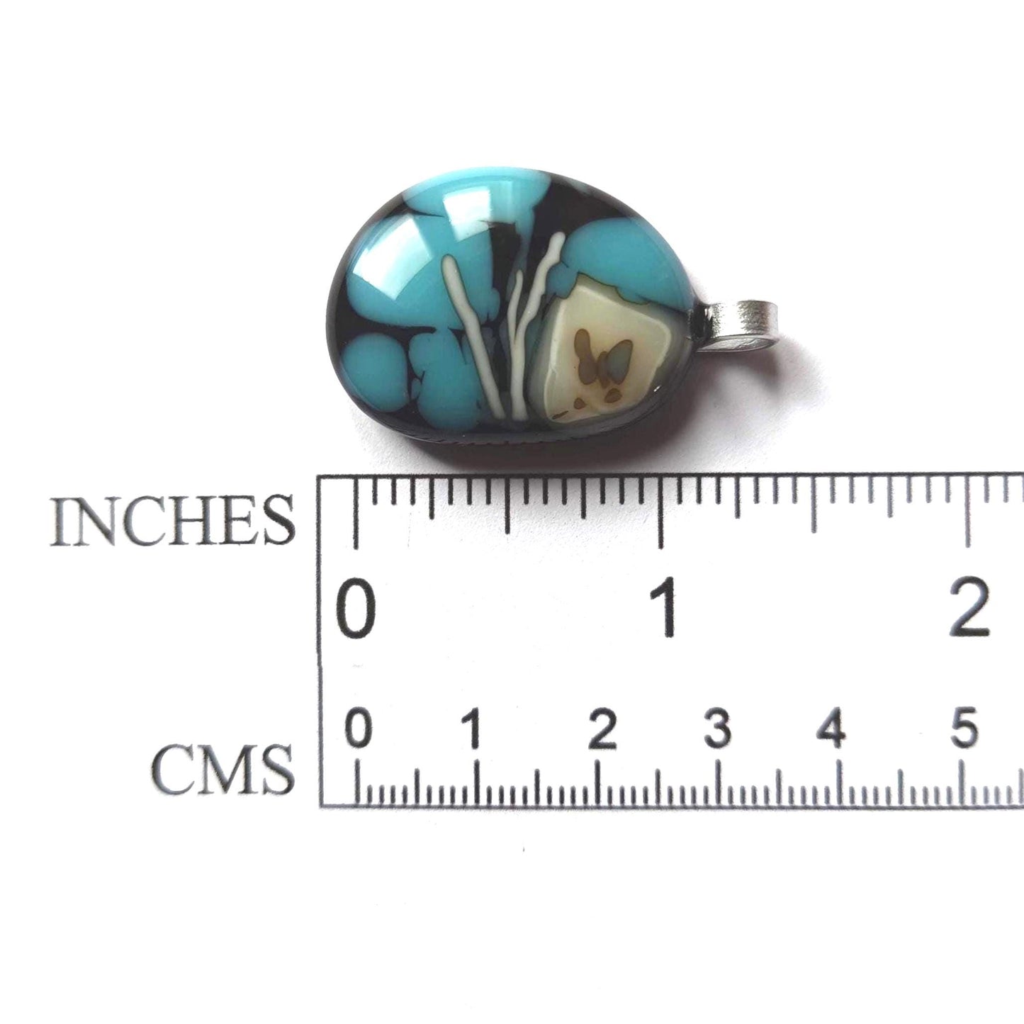 Fused glass pendant necklace in blue and black tones with white swirls and a silver bail on a black cord.