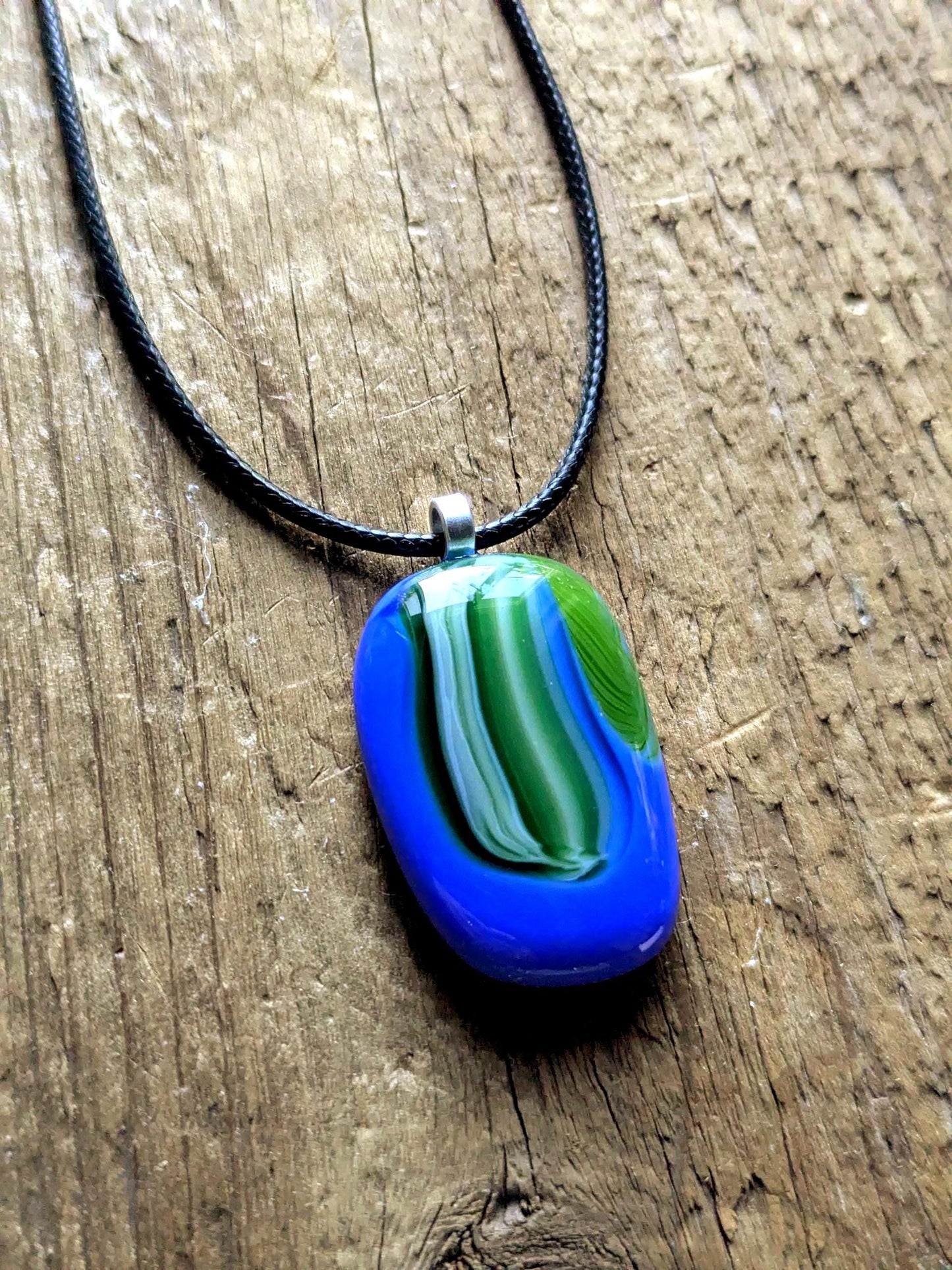 Fused glass pendant on black cord necklace; oval blue pendant with green swirls, handmade jewellery, unique one-of-a-kind.