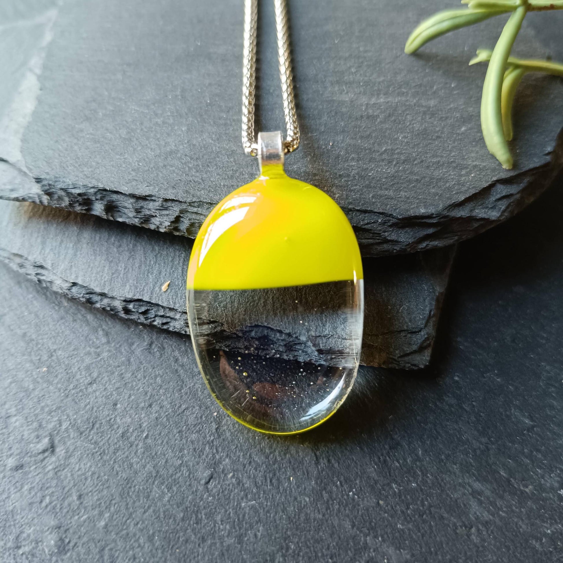 Handcrafted lime green and clear fused glass oval pendant necklace on a silver chain.