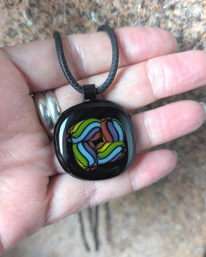Fused glass pendant on black cord necklace; vibrant rainbow swirls, handmade one-of-a-kind letterbox gift.