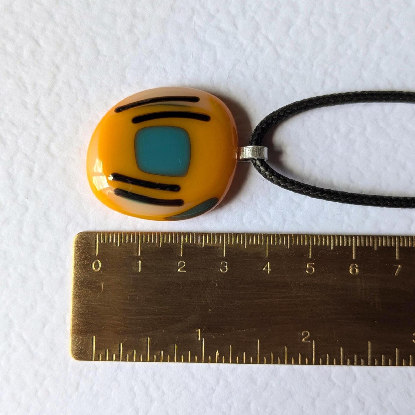 Orange fused glass pendant with blue square and black lines on a black cord necklace - boho statement handmade jewellery.