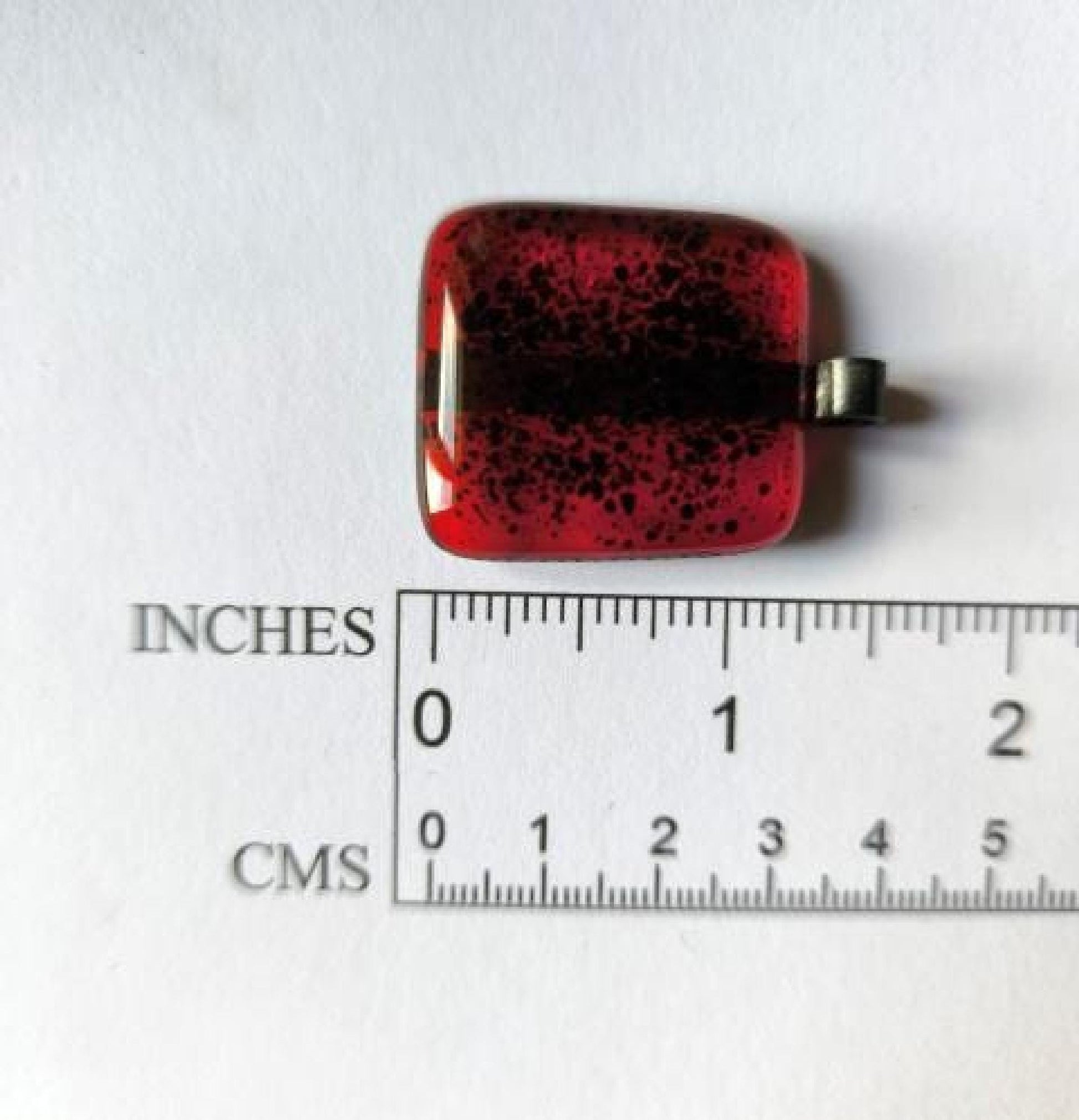 Red transparent fused glass pendant on a dark cord necklace; handmade necklace with black speckles.
