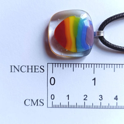 Handmade fused glass rainbow pendant necklace on a silver chain; colorful stripes in a clear rounded-square pendant.