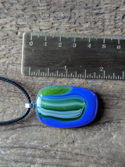 Fused glass pendant on black cord necklace; oval blue pendant with green swirls, handmade jewellery, unique one-of-a-kind.