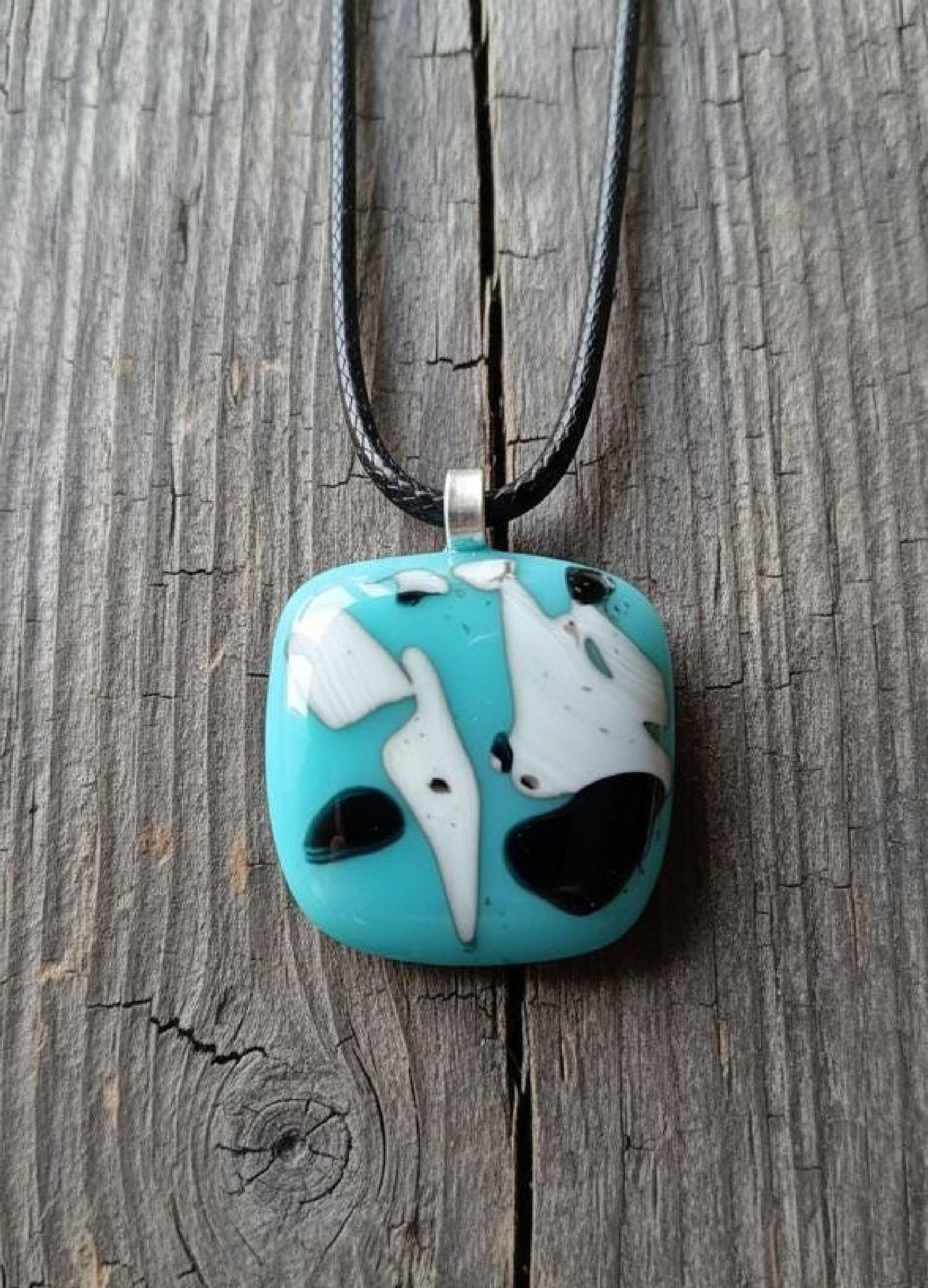 Fused glass pendant on black cord; turquoise blue square with white and black abstract patterns, handmade, easy to mail.