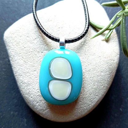 Turquoise fused glass pendant necklace with two pale inlay shapes on a black cord - handmade jewelry, one of a kind.