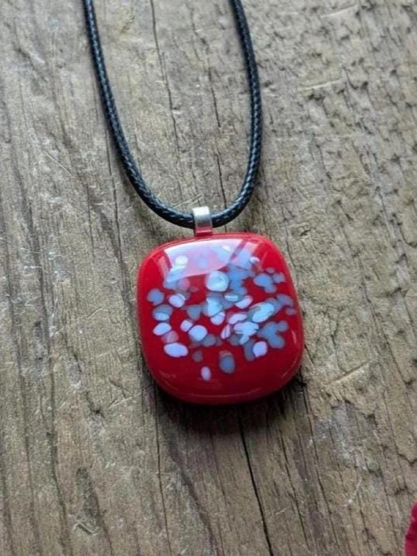 Red fused glass speckled pendant on brown cord necklace; one-of-a-kind handmade jewellery.
