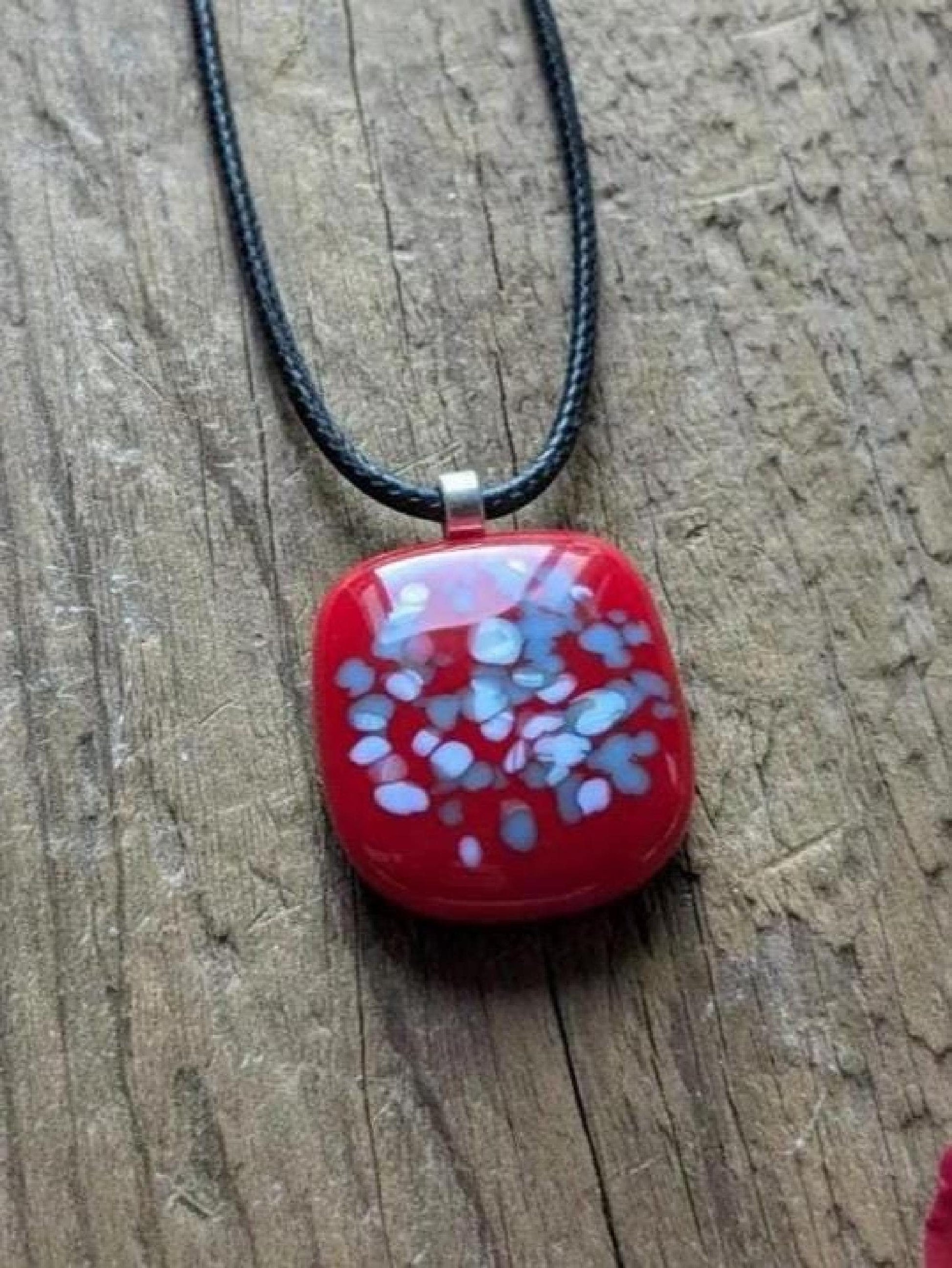 Red fused glass speckled pendant on brown cord necklace; one-of-a-kind handmade jewellery.
