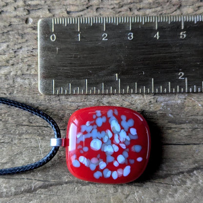 Red fused glass speckled pendant on brown cord necklace; one-of-a-kind handmade jewellery.
