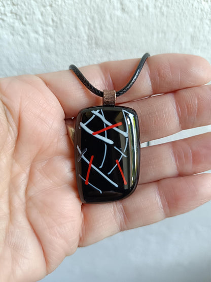 Fused glass pendant on black cord necklace with abstract white, blue, red lines; quirky art pendant, handmade jewellery.