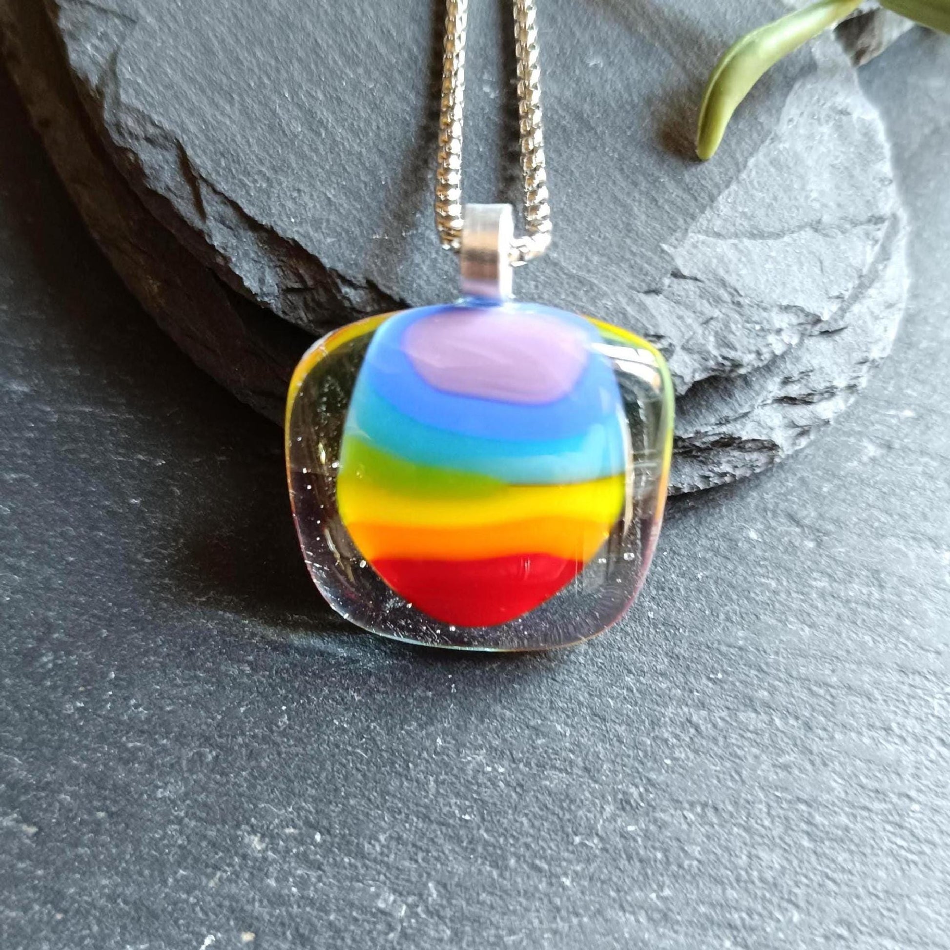 Handmade fused glass rainbow pendant necklace on a silver chain; colorful stripes in a clear rounded-square pendant.
