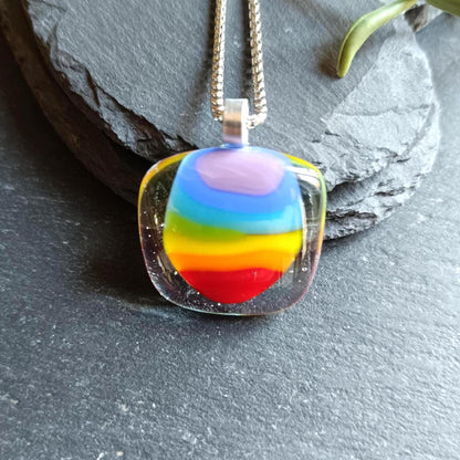 Handmade fused glass rainbow pendant necklace on a silver chain; colorful stripes in a clear rounded-square pendant.