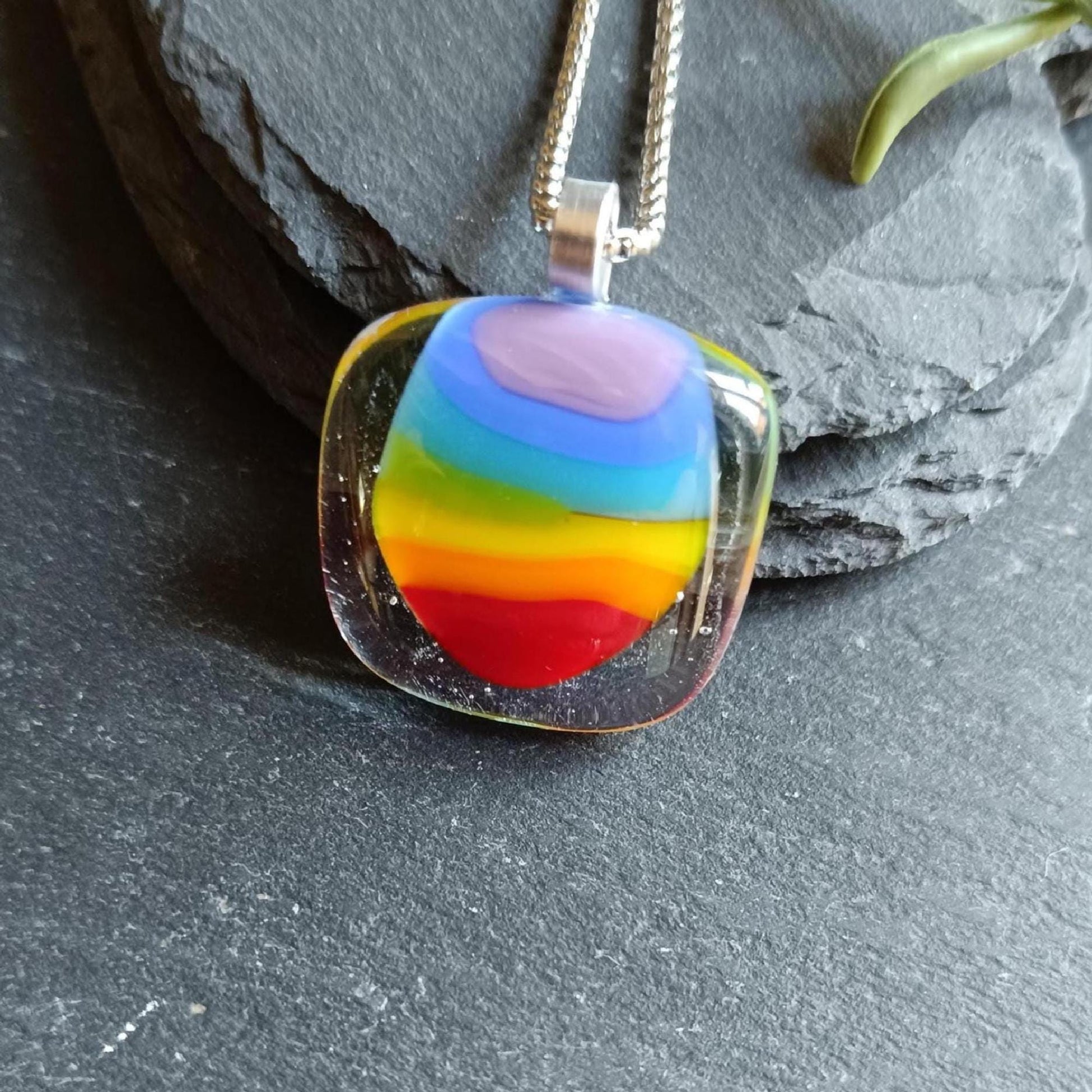Handmade fused glass rainbow pendant necklace on a silver chain; colorful stripes in a clear rounded-square pendant.