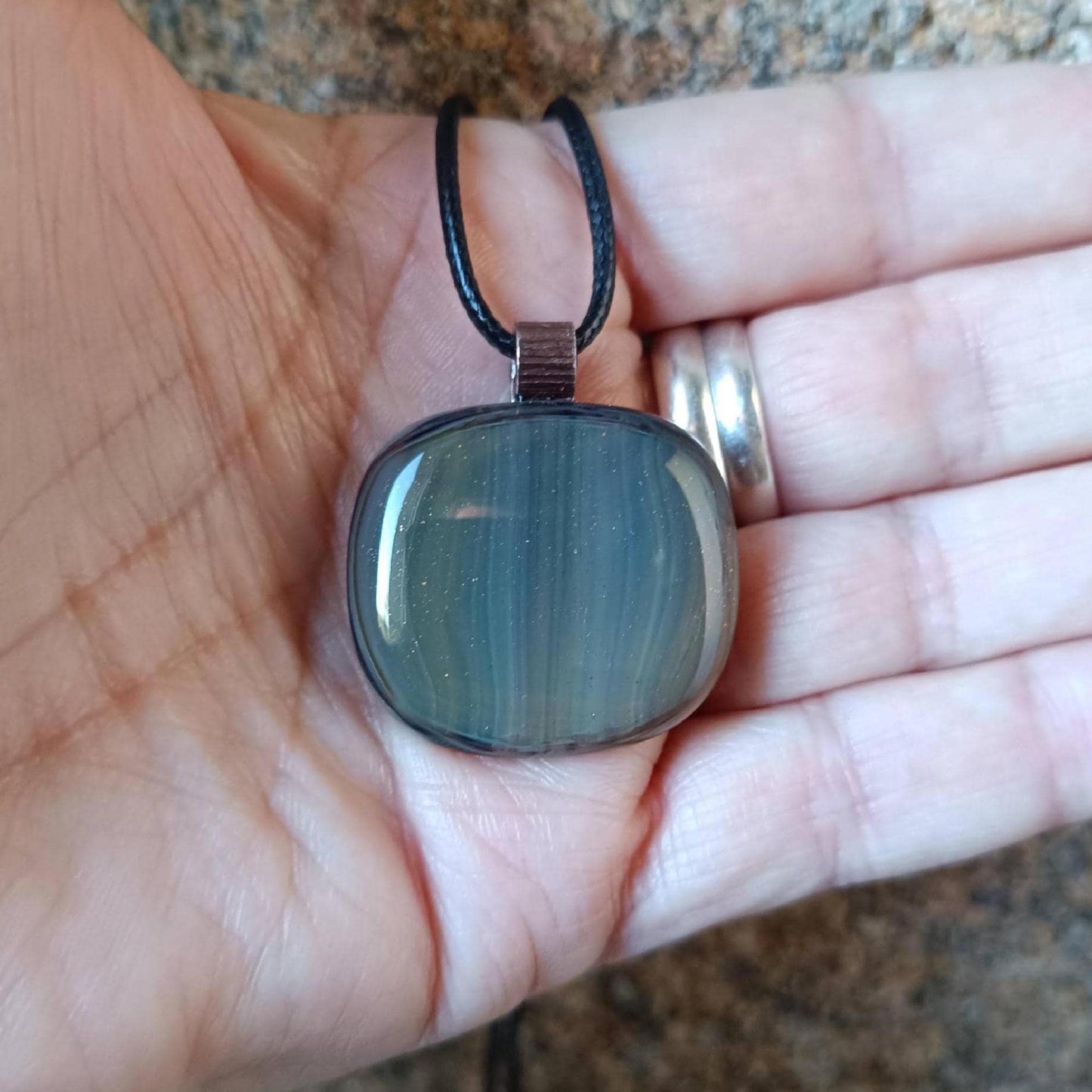 Fused glass pendant necklace with blue-green striped pendant, copper bail on black cord—artisan handmade jewellery, gift.