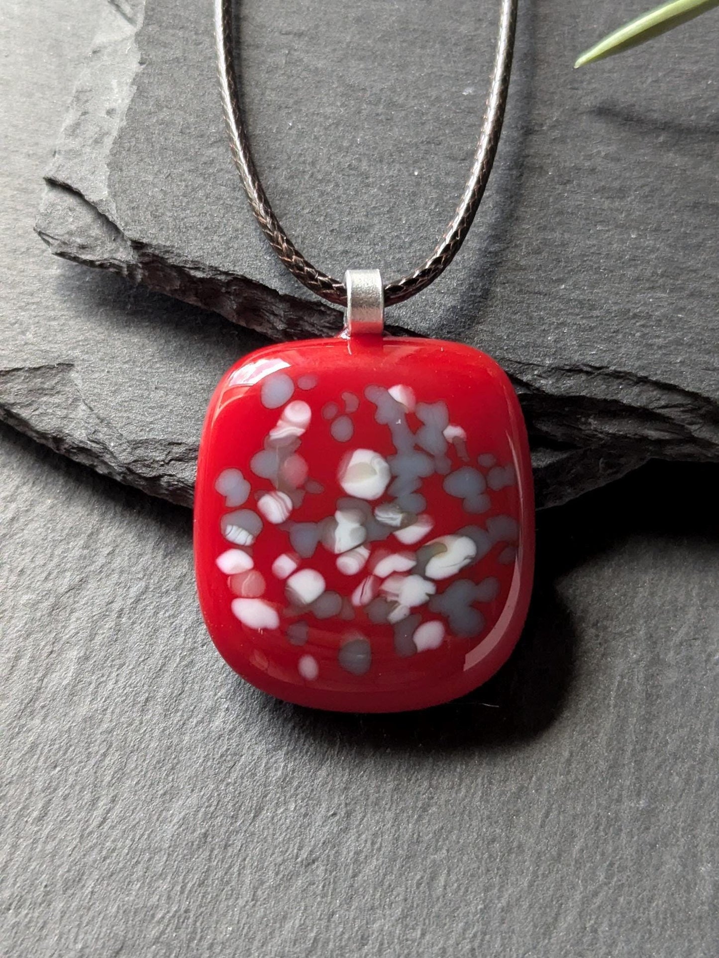 Red fused glass speckled pendant on brown cord necklace; one-of-a-kind handmade jewellery.